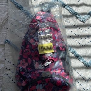 Brand new waterfly one strap backpack in the color pink with bright flowers